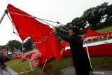 Petugas BPBD mengevakuasi tenda stan pameran UMKM  yang berserakan akibat diterjang hujan disertai angin di Alun-Alun Kota Blitar, Jawa Timur, Minggu (5/11/2021). Puluhan tenda stan pameran UMKM tersebut rusak akibat diterjang hujan deras yang disertai angin kencang, dampak cuaca buruk di daerah itu. Antara Jatim/Irfan Anshori/zk.