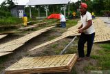 Perajin mengentas kerupuk lempeng mentah di tempat penjemuran di Desa Blimbing, Dolopo, Kabupaten Madiun, Jawa Timur, Sabtu (4/12/2021). Perajin tersebut memproduksi kerupuk lempeng mentah berbahan pokok tepung terigu dan tepung kanji 1,5 kuintal per hari dan dijual dengan harga Rp35 ribu per kemasan berisi 2,5 kilogram. Antara Jatim/Siswowidodo/zk.