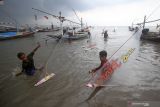 Peserta menyiapkan perahu saat mengikuti lomba balap perahu layar mini di Pantai Kenjeran, Bulak Cumpat, Surabaya, Jawa Timur, Sabtu (4/12/2021). Kegiatan yang diikuti 102 peserta tersebut guna menarik wisatawan sekaligus penyaluran hobi balap perahu layar mini bagi masyarakat nelayan di sekitar Pantai Kenjeran. Antara Jatim/Moch Asim/zk.