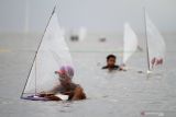 Peserta menyiapkan perahu saat mengikuti lomba balap perahu layar mini di Pantai Kenjeran, Bulak Cumpat, Surabaya, Jawa Timur, Sabtu (4/12/2021). Kegiatan yang diikuti 102 peserta tersebut guna menarik wisatawan sekaligus penyaluran hobi balap perahu layar mini bagi masyarakat nelayan di sekitar Pantai Kenjeran. Antara Jatim/Moch Asim/zk.