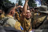 Seorang perangkat desa yang tergabung dalam Persatuan Perangkat Desa Indonesia (PPDI) menyampaikan pendapatnya saat melakukan aksi di Depan Gedung Sate, Bandung, Jawa Barat, Senin (6/12/2021). Mereka menuntut agar Pemerintah Provinsi Jawa Barat dapat menambah tunjangan aparatur pemerintah desa melalui bantuan keuangan provinsi. ANTARA FOTO/Raisan Al Farisi/agr