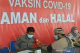 Petugas memeriksa kesehatan warga sebelum disuntik vaksin COVID-19 di gedung Taman Budaya, Banda Aceh, Aceh, Senin (6/12/2021). Pemerintah akan melakukan vaksinasi  COVID-19 dosis ketiga atau booster/penguat secara paralel pada Januari 2022 kepada masyarakat secara gratis dan sebagian lainnya berbayar. ANTARA FOTO/Ampelsa