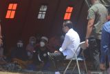 Presiden Joko Widodo (kedua kanan) mengunjungi korban bencana Gunung Semeru di posko pengungsian Desa Sumberwuluh, Candipuro, Lumajang, Jawa Timur, Selasa (7/12/2021). Dalam kunjungan tersebut presiden menyapa, berdialog dan memberikan dukungan kepada korban letusan Gunung Semeru. Antara Jatim/Seno/Zabur Karuru