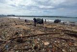 Sejumlah nelayan beraktivitas di tengah tumpukan sampah yang berserakan di Pantai Kedonganan, Badung, Bali, Selasa (7/12/2021). Cuaca ekstrem yang melanda Bali pada Senin (6/12/2021) tersebut menyebabkan berbagai sampah terdampar di pesisir pantai akibat terbawa gelombang laut sehingga mencemari kawasan pariwisata itu. ANTARA FOTO/Nyoman Hendra Wibowo/nym.