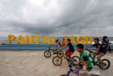 Pengunjung berfoto di pantai wisata Jawa-Hagu (JAGU), Kota Lhokseumawe, Aceh, Selasa (7/12/2021). Kementerian PUPR melalui program Kota Tanpa Kumuh (Kotaku) mengembangkan kawasan kumuh kota menjadi destinasi wisata kuliner Pantai JAGU untuk membangkitkan ekonomi masyarakat melalui pariwisata. ANTARA FOTO/Rahmad