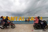 Pengunjung berfoto di pantai wisata Jawa-Hagu (JAGU), Kota Lhokseumawe, Aceh, Selasa (7/12/2021). Kementerian PUPR melalui program Kota Tanpa Kumuh (Kotaku) mengembangkan kawasan kumuh kota menjadi destinasi wisata kuliner Pantai JAGU untuk membangkitkan ekonomi masyarakat melalui pariwisata. ANTARA FOTO/Rahmad