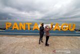 Pengunjung berfoto di pantai wisata Jawa-Hagu (JAGU), Kota Lhokseumawe, Aceh, Selasa (7/12/2021). Kementerian PUPR melalui program Kota Tanpa Kumuh (Kotaku) mengembangkan kawasan kumuh kota menjadi destinasi wisata kuliner Pantai JAGU untuk membangkitkan ekonomi masyarakat melalui pariwisata. ANTARA FOTO/Rahmad