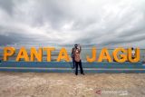 Pengunjung berfoto di pantai wisata Jawa-Hagu (JAGU), Kota Lhokseumawe, Aceh, Selasa (7/12/2021). Kementerian PUPR melalui program Kota Tanpa Kumuh (Kotaku) mengembangkan kawasan kumuh kota menjadi destinasi wisata kuliner Pantai JAGU untuk membangkitkan ekonomi masyarakat melalui pariwisata. ANTARA FOTO/Rahmad