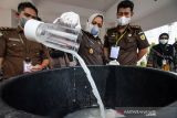 Kajari Aceh Utara Diah Ayu Hartati (kanan) disaksikan perwakilan pihak terkait memasukkan barang bukti tindak pidana narkoba jenis sabu ke dalam blender saat pemusnahan barang bukti narkotika di Kantor Kejaksaan Negeri Aceh Utara, Aceh, Kamis (9/12/2021). Kejaksaan Negeri Aceh Utara memusnahkan sebanyak 5,85 kilogram barang bukti tindak pidana narkotika yang sudah memiliki kekuatan hukum tetap selama kurun waktu tahun 2021. ANTARA FOTO/Rahmad