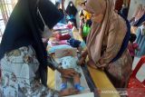 Petugas kesehatan menidurkan nak balita untuk mengukur tinggi badannya pada kegiatan imunisasi anak di Puskesmas Desa Doy, Kecamatan Ulee Kareueng, Banda Aceh, Aceh, Jumat (10/12/2021). Kementerian Kesehatan meminta pemerintah daerah meningkatkan cakupan imunisasi dasar pada anak balita dan anak usia sekolah yang secara nasional baru mencapai angka 58,4 persen per Oktober 2021 atau masih rendah dari target 79,1 persen. ANTARA FOTO/Ampelsa