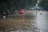 Kendaraan menerobos banjir di Jalan Soekarno-Hatta, Gedebage, Bandung, Jawa Barat, Minggu (12/12/2021). Banjir setinggi 30-60 sentimeter akibat hujan lebat di berbagai wilayah di Kota Bandung membuat saluran drainase tidak mampu menampung volume air yang tinggi. ANTARA FOTO/Raisan Al Farisi/agr