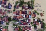 Foto udara suasana permukiman warga yang terendam banjir di Desa Karangligar, Karawang, Jawa Barat, Minggu (12/12/2021). Badan Penanggulangan Bencana Daerah (BPBD) Karawang mencatat sebanyak 236 rumah dan 829 jiwa terdampak banjir di wilayah itu yang disebabkan meluapnya air sungai Citarum. ANTARA FOTO/M Ibnu Chazar/agr