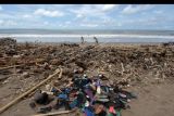Wisatawan berjalan di dekat tumpukan sampah yang berserakan di sepanjang Pantai Berawa, Kuta Utara, Badung, Bali, Minggu (12/12/2021). Sampah tersebut terbawa arus laut yang kemudian terdampar sehingga mencemari kawasan pariwisata. ANTARA FOTO/Nyoman Hendra Wibowo/nym.