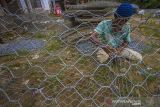 Pekerja menyelesaikan bronjong material pembuatan tanggul sungai di Desa Datar Ajab, Kabupaten Hulu Sungai Tengah, Kalimantan Selatan, Senin (13/12/2021). Pemerintah daerah setempat berupaya mngantisipasi ancaman banjir yang kerap terjadi di wilayah itu dengan membuat tanggul sungai di daerah hulu sungai. ANTARA FOTO/Bayu Pratama S.