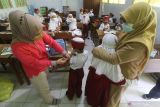 Petugas kesehatan menyuntikkan vaksin Difteri Tetanus (DT) kepada murid kelas satu saat bulan imunisasi anak sekolah (BIAS) di Madrasah Ibtidaiyah Negeri 2 Kediri, Jawa Timur, Selasa (14/12/2021). BIAS diselenggarakan secara serentak di sejumlah daerah sebanyak dua kali dalam setahun guna menjamin pelajar mendapatkan perlindungan terhadap penyakit campak, difteri, dan tinanus. Antara Jatim/Prasetia Fauzani/zk