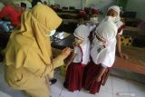 Petugas kesehatan menyuntikkan vaksin Difteri Tetanus (DT) kepada murid kelas satu saat bulan imunisasi anak sekolah (BIAS) di Madrasah Ibtidaiyah Negeri 2 Kediri, Jawa Timur, Selasa (14/12/2021). BIAS diselenggarakan secara serentak di sejumlah daerah sebanyak dua kali dalam setahun guna menjamin pelajar mendapatkan perlindungan terhadap penyakit campak, difteri, dan tinanus. Antara Jatim/Prasetia Fauzani/zk