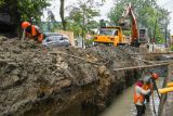 Pekerja dengan menggunakan alat berat memperbaiki drainase di Jalan Sei Belutu, Medan, Sumatera Utara, Kamis (9/12/2021). Pemerintah daerah setempat memperbaiki drainase untuk mengantisipasi genangan saat hujan lebat.