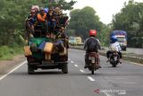 Sejumlah warga berada di atas mobil bak terbuka melintas di Jalur pantura, Losarang, Indramayu, Jawa Barat, Rabu (15/12/2021). Selain dapat membahayakan diri sendiri perilaku tersebut juga dapat membahayakan pengguna jalan lain. ANTARA FOTO/Dedhez Anggara/agr