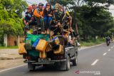 Sejumlah warga berada di atas mobil bak terbuka melintas di Jalur pantura, Losarang, Indramayu, Jawa Barat, Rabu (15/12/2021). Selain dapat membahayakan diri sendiri perilaku tersebut juga dapat membahayakan pengguna jalan lain. ANTARA FOTO/Dedhez Anggara/agr