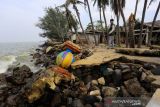 Warga berada di sekitar bangunan yang rusak akibat abrasi di pantai Eretan, Indramayu, Jawa Barat, Rabu (15/12/2021). Sejumlah kawasan di pantai tersebut mengalami abrasi akibat gelombang pasang air laut yang terjadi pada beberapa pekan terakhir. ANTARA FOTO/Dedhez Anggara/agr
