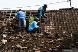 Warga membenahi genteng rumah yang rusak akibat puting beliung di Desa Sidomulyo, Wonoasri, Kabupaten Madiun, Jawa Timur, Kamis (16/12/2021). Sebanyak 515 bangunan terdiri rumah warga, gedung sekolah, toko, warung di empat desa yaitu Sidomulyo, Ngadirejo, Plumpungrejo, Jatirejo mengalami rusak berat, ringan dan sebagian roboh akibat puting beliung yang terjadi saat hujan deras, Rabu (15/12). Antara Jatim/Siswowidodo/zk