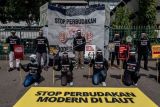 Aktivis Serikat Buruh Migran Indonesia (SBMI) bersama Greenpeace Indonesia dan BEM BREGAS (Brebes, Tegal, Slawi) menggelar aksi damai Setop Perbudakan Modern di Laut, di depan Kantor Gubernur Jawa Tengah, Semarang, Jawa Tengah, Jumat (17/12/2021). Dalam aksi yang digelar jelang peringatan Hari Buruh Migran Internasional itu mereka mendesak pemerintah Provinsi Jawa Tengah turut mengambil langkah nyata guna memutus mata rantai praktik penipuan, penjeratan utang, dan kerja paksa dalam perekrutan serta penempatan anak buah kapal (ABK) asal Indonesia di kapal ikan asing. ANTARA FOTO/Aji Styawan/tom.