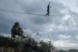 Pegiat olahraga ekstrem berjalan di atas tali webbing pada kegiatan Bandung Highlines Festival di Tebing Hawu, Kabupaten Bandung Barat, Jawa Barat, Sabtu (18/12/2021). Kegiatan tersebut menjadi ajang berkumpulnya para pegiat olahraga slackline yang menitikberatkan pada keseimbangan dan konsentrasi sekaligus sebagai upaya menjaga serta melestarikan Tebing Hawu yang termasuk kawasan konservasi Karst Citatah. ANTARA FOTO/Novrian Arbi/agr