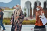 Wisatawan mengunjungi objek wisata religi Masjid Raya Baiturrahman, Banda Aceh, Minggu (19/12/2021). Pemerintah mengimbau masyarakat meningkatkan disiplin melaksanakan protokol kesehatan  untuk mencegah gelombang penularan COVID-19 dan ancaman varian baru Omicron terutama menjelang liburan tahun baru. ANTARA FOTO/Ampelsa.