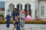 Wisatawan mengunjungi objek wisata religi Masjid Raya Baiturrahman, Banda Aceh, Minggu (19/12/2021). Pemerintah mengimbau masyarakat meningkatkan disiplin melaksanakan protokol kesehatan  untuk mencegah gelombang penularan COVID-19 dan ancaman varian baru Omicron terutama menjelang liburan tahun baru. ANTARA FOTO/Ampelsa.