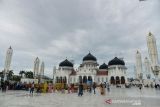 Wisatawan mengunjungi objek wisata sejarah Masjid Raya Baiturrahman, Banda Aceh, Aceh, Minggu (19/12/2021). Kementerian Pariwisata dan Ekonomi Kreatif manargetkan pad atahun 2022, peroleh  devisa dari sektor pariwisata dan ekonomi kreatif pada angka US$ 0,47 miliar hingga US$ 1,7 miliar seiring rencana pemerintah membuka kembali destinasi wisata unggulan. ANTARA FOTO/Ampelsa.