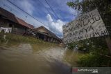 Sebuah papan peringatan terpasang di permukiman yang terendam banjir di Desa Dalam Pagar Ulu, Kabupaten Banjar, Kalimantan Selatan, Senin (20/12/2021). Banjir yang disebabkan meluapnya sungai Martapura dan sungai Kiwa itu telah merendam sejumlah desa di enam Kecamatan di Kabupaten Banjar. Foto Antaranews Kalsel/Bayu Pratama S.