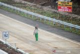 Pekerja membuat marka jalan pada proyek Jalan Tol Cileunyi-Sumedang-Dawuan (Cisumdawu) di Jatinangor, Kabupaten Sumedang,  Jawa Barat, Selasa (21/12/2021). Satuan kerja Jalan Tol Cisumdawu berencana membuka secara fungsional ruas jalan seksi 1 (Cileunyi-Pamulihan) sebelum libur Natal 2021 dan Tahun Baru. ANTARA FOTO/Raisan Al Farisi/agr