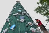 Warga menghias pohon Natal di Halaman Gereja Katolik Santo Yohanes, Kabupaten Ciamis, Jawa Barat, Selasa (21/12/2021). Jelang perayaan Natal umat Kristiani membuat pohon Natal yang dihiasi dengan berbagai tulisan protokol kesehatan guna mengampanyekan penerapan protokol kesehatan selama pandemi COVID-19. ANTARA FOTO/Adeng Bustomi/agr