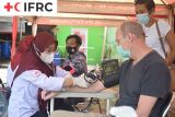 Petugas PMI Kota Tangerang sedang melakukan pemeriksaan kesehatan kepada seorang WNA sebelum dilakukan vaksinasi COVID-19. (Antara/PMI/IFRC).