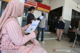 Petugas membagikan kartu vaksin kepada calon penumpang yang telah mengikuti vaksinasi COVID-19 sebelum melakukan perjalanan kereta api di Stasiun Jatibarang, Indramayu, Jawa Barat, Sabtu (25/12/2021). PT KAI Daop 3 Cirebon memberikan layanan tes PCR dan vaksinasi Covid-19 bagi calon penumpang sebagai syarat perjalanan kereta api selama libur Natal dan Tahun Baru. ANTARA FOTO/Dedhez Anggara/agr