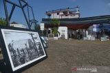 Pengunjung menyaksikan pameran foto Tsunami Pandemi di situs tsunami Kapal Atas Rumah, Desa Lampulo, Banda Aceh, Aceh, Sabtu (25/12/2021). Pewarta Foto Indonesia (PFI) Aceh menggelar pameran foto dengan tema Tsunami Pandemi Siaga Bencana Tangguh Bersama melawan COVID-19 dalam rangka peringatan 17 tahun Tsunami Aceh 26 Desember 2021. ANTARA FOTO/Ampelsa