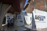 Pengunjung menyaksikan pameran foto Tsunami Pandemi di situs tsunami Kapal Atas Rumah, Desa Lampulo, Banda Aceh, Aceh, Sabtu (25/12/2021). Pewarta Foto Indonesia (PFI) Aceh menggelar pameran foto dengan tema Tsunami Pandemi Siaga Bencana Tangguh Bersama melawan COVID-19 dalam rangka peringatan 17 tahun Tsunami Aceh 26 Desember 2021. ANTARA FOTO/Ampelsa