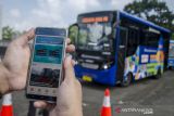 Warga membuka aplikasi Teman Bus untuk layanan bus Trans Metro Pasundan saat peresmian di Monumen Perjuangan Rakyat Jawa Barat, Bandung, Jawa Barat, Senin (27/12/2021). Kementerian Perhubungan meluncurkan Teman Bus melalui program 