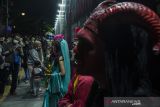 Warga berfoto dengan cosplayer di kawasan Asia Afrika saat malam tahun baru di Bandung, Jawa Barat, Jumat (31/12/2021). Warga tampak memadati kawasan tersebut untuk berwisata malam pergantian tahun 2021 ke 2022. ANTARA FOTO/Novrian Arbi/agr