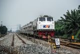 Kereta api melintas di samping proyek jalur ganda kereta api Cicalengka-Kiaracondong di Cimekar, Bandung, Jawa Barat, Jumat (31/12/2021). Direktorat Jenderal Perkeretaapian (DJKA) Kementerian Perhubungan mencatat selama tahun 2021 DJKA telah membangun setidaknya 177,26 kilometer jalur kereta api di sejumlah daerah di Indonesia. ANTARA FOTO/Raisan Al Farisi/agr