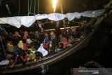 Pengungsi etnis Rohingya menunggu di atas kapal saat proses evakuasi oleh TNI AL ke Pelabuhan ASEAN, Krueng Geukuh, Aceh Utara, Aceh, Jumat (31/12/2021). Pemerintah Indonesia melalui Satgas Penanganan Pengungsi Luar Negeri (PPLN) mempertimbangkan keadaan darurat dan sisi kemanusiaan sehingga memutuskan untuk menyelamatkan 120 orang etnis Rohingya terdiri dari tujuh laki-laki, 62 perempuan dan 51 anak-anak yang terdampar di perairan laut Aceh pada Sabtu (25/12/2021). ANTARA FOTO/Rahmad