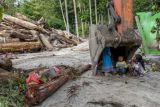 Sejumlah anak bernaung di bawah sendok ekskavator usai terjadi banjir bandang susulan di Desa Rogo, Dolo Selatan, Sigi, Sulawesi Tengah, Senin (6/9/2021). Setelah diterjang banjir bandang pada Sabtu (29/8) lalu, desa itu kembali dilanda banjir bandang susulan pada Minggu (5/9) malam yang mengakibatkan puluhan rumah kembali terendam lumpur dan ratusan warga kembali mengungsi ke tempat aman. ANTARA FOTO/Basri Marzuki/WSJ.