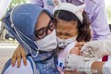 Seorang ibu menemani anaknya yang menangis saat mengikuti vaksinasi anak usia 6-11 tahun di Karawang, Jawa Barat, Senin (3/1/2022). Pemerintah Kabupaten Karawang melaksanakan vaksinasi anak usia 6-11 tahun secara serentak di 50 Puskesmas dan 12 Sekolah Dasar dengan target sasaran sebanyak 239.623 anak untuk mendukung Pembelajaran Tatap Muka (PTM) dan mencegah penularan COVID-19 di sekolah. ANTARA FOTO/M Ibnu Chazar/agr