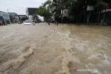 Sejumlah warga berjalan menembus banjir yang melanda Kota Lhoksukon, Aceh Utara, Aceh, Senin (3/1/2022). Data dari Badan Penanggulangan Bencana Daerah (BPBD) Aceh Utara mencatat banjir yang merendam 14 Kecamatan di daerah tersebut mengakibatkan 2.278 jiwa terdampak dan satu orang anak meninggal dunia. ANTARA FOTO/Rahmad