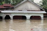 Sejumlah warga berjalan menembus banjir yang melanda Kota Lhoksukon, Aceh Utara, Aceh, Senin (3/1/2022). Data dari Badan Penanggulangan Bencana Daerah (BPBD) Aceh Utara mencatat banjir yang merendam 14 Kecamatan di daerah tersebut mengakibatkan 2.278 jiwa terdampak dan satu orang anak meninggal dunia. ANTARA FOTO/Rahmad