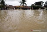 Sejumlah warga berjalan menembus banjir yang melanda Kota Lhoksukon, Aceh Utara, Aceh, Senin (3/1/2022). Data dari Badan Penanggulangan Bencana Daerah (BPBD) Aceh Utara mencatat banjir yang merendam 14 Kecamatan di daerah tersebut mengakibatkan 2.278 jiwa terdampak dan satu orang anak meninggal dunia. ANTARA FOTO/Rahmad