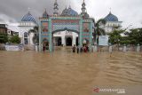 Sejumlah warga berjalan menembus banjir yang melanda Kota Lhoksukon, Aceh Utara, Aceh, Senin (3/1/2022). Data dari Badan Penanggulangan Bencana Daerah (BPBD) Aceh Utara mencatat banjir yang merendam 14 Kecamatan di daerah tersebut mengakibatkan 2.278 jiwa terdampak dan satu orang anak meninggal dunia. ANTARA FOTO/Rahmad