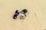 Sejumlah warga berjalan menembus banjir yang melanda Kota Lhoksukon, Aceh Utara, Aceh, Senin (3/1/2022). Data dari Badan Penanggulangan Bencana Daerah (BPBD) Aceh Utara mencatat banjir yang merendam 14 Kecamatan di daerah tersebut mengakibatkan 2.278 jiwa terdampak dan satu orang anak meninggal dunia. ANTARA FOTO/Rahmad.