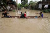 Sejumlah warga menggunakan perahu saat banjir melanda Kota Lhoksukon, Aceh Utara, Aceh, Senin (3/1/2022). Data dari Badan Penanggulangan Bencana Daerah (BPBD) Aceh Utara mencatat banjir yang merendam 14 Kecamatan di daerah tersebut mengakibatkan 2.278 jiwa terdampak dan satu orang anak meninggal dunia. ANTARA FOTO/Rahmad/rwa.