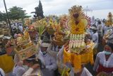 Sejumlah umat Hindu membawa perangkat upacara yang merupakan simbol arwah anggota keluarganya dalam upacara Nyegara Gunung di Pantai Goa Lawah, Klungkung, Bali, Selasa (4/1/2022). Upacara yang dilaksanakan setelah Ngaben atau kremasi jenazah tersebut merupakan ritual tahap akhir berupa doa-doa dan penyucian terhadap 214 arwah. ANTARA FOTO/Nyoman Budhiana. 